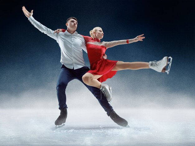 Patineurs artistiques professionnels homme et femme effectuant un spectacle ou une compétition sur la patinoire