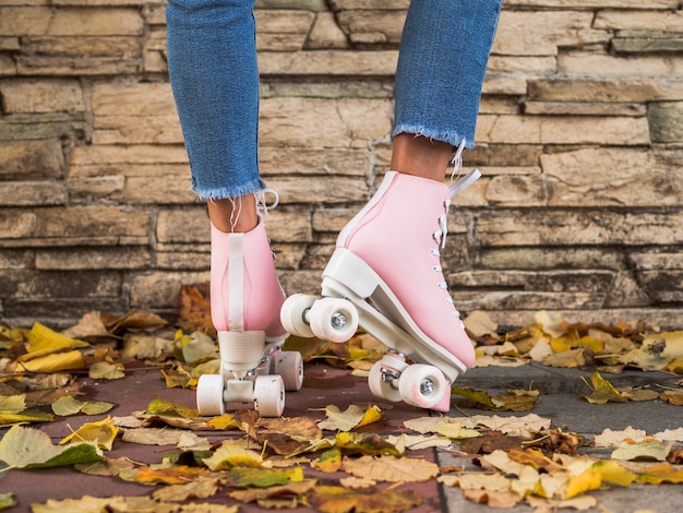 Patins à roulettes avec femme en jeans et feuilles