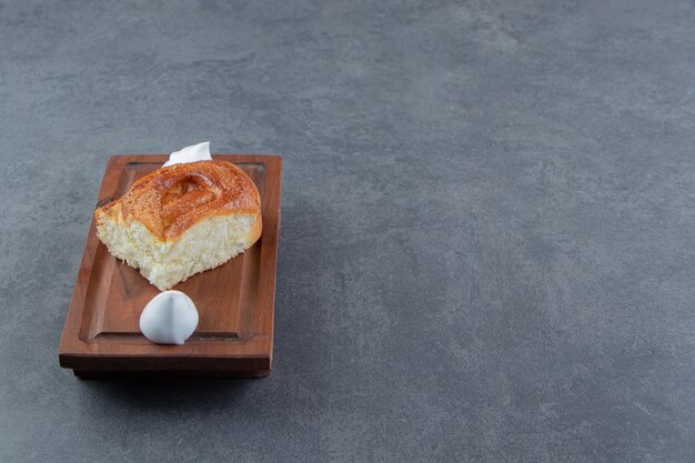 Pâtisserie et crème maison savoureuses sur planche de bois.