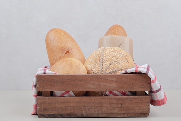 Pâtisserie fraîche de pain sur panier en bois avec nappe. Photo de haute qualité