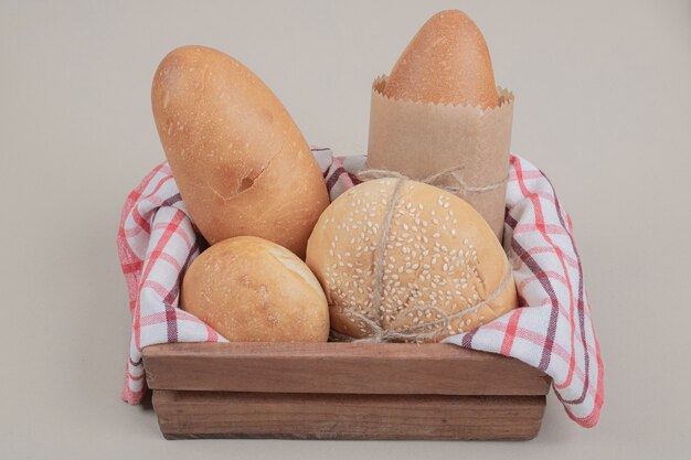 Pâtisserie fraîche de pain sur panier en bois avec nappe