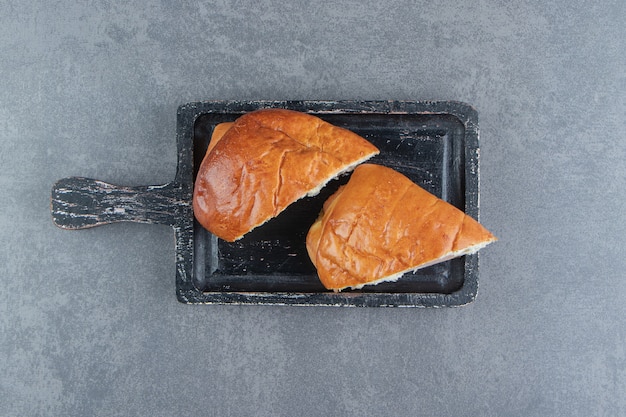 Pâtisserie maison en tranches sur une planche à découper noire.