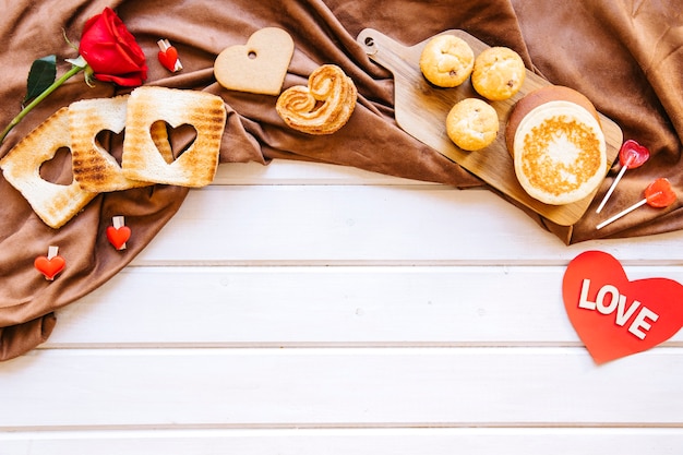 Photo gratuite pâtisserie et rose sur toile marron