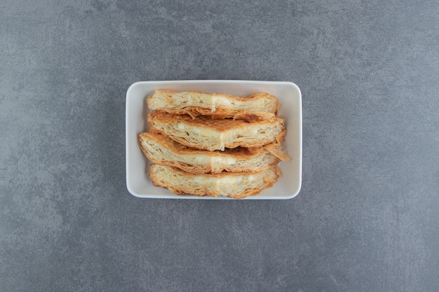 Pâtisseries faites maison avec du fromage sur une plaque blanche.