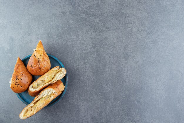 Pâtisseries fraîches aux graines de sésame sur plaque bleue.