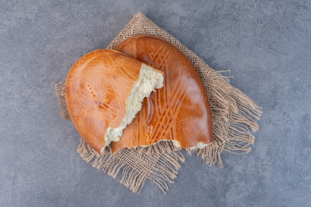 Pâtisseries sucrées maison demi-coupées sur toile de jute.