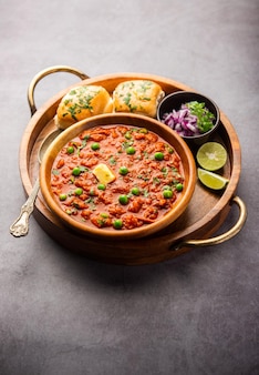 Pav bhaji est un plat de restauration rapide de l'inde composé d'un curry de légumes épais servi avec un petit pain moelleux