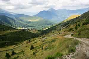 Photo gratuite paysage de collines couvertes de verdure avec des montagnes rocheuses