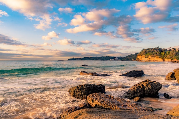 Paysage à couper le souffle d'une plage rocheuse sur un beau coucher de soleil