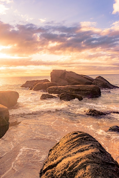 Paysage à couper le souffle d'une plage rocheuse sur un magnifique coucher de soleil