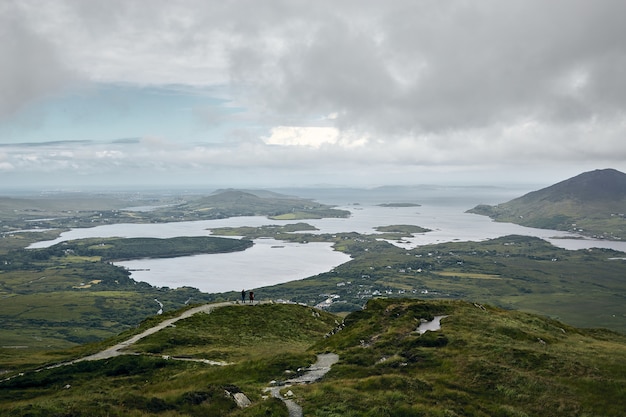 Photo gratuite paysage du parc national du connemara entouré par la mer sous un ciel nuageux en irlande
