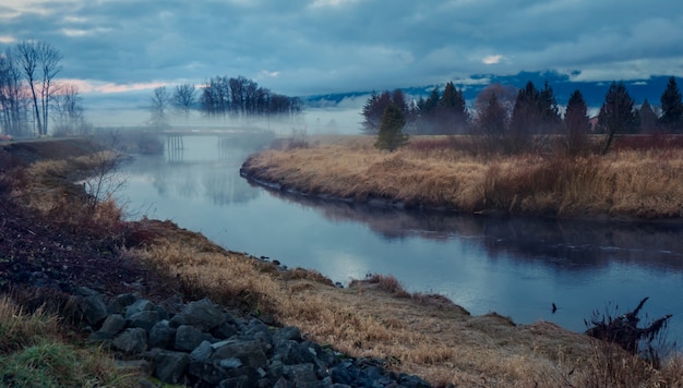 Photo gratuite paysage avec lac et brouillard