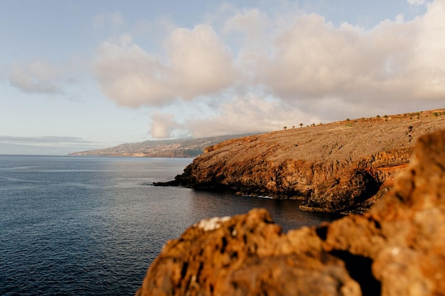 Paysage d'un large océan bleu calme avec des rochers orange sauvages au coucher du soleil Puissance de la nature Liberté Voyage