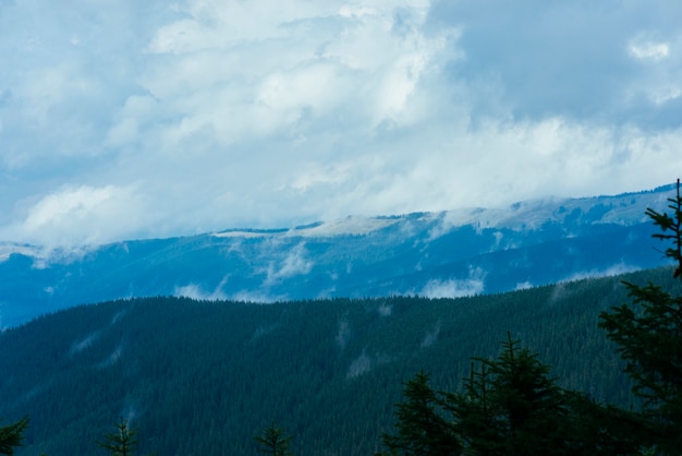 Paysage de montagne en couches dans le ciel bleu de brume avec des nuages