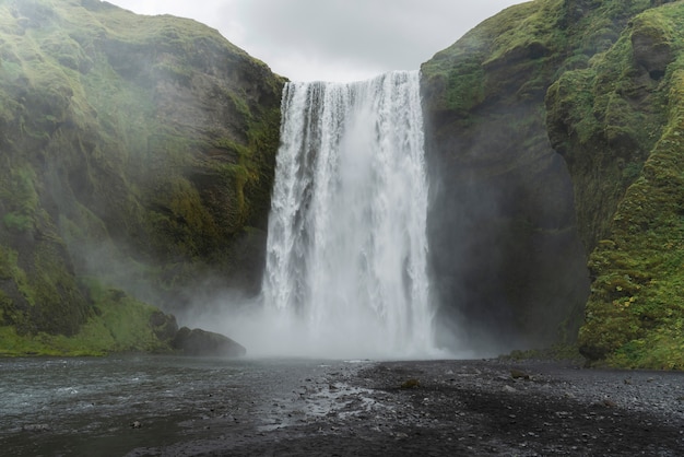 Photo gratuite paysage naturel nuageux près de la cascade