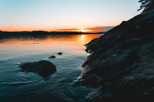 Paysage d'un rivage rocheux entouré par la mer lors d'un beau lever de soleil le matin