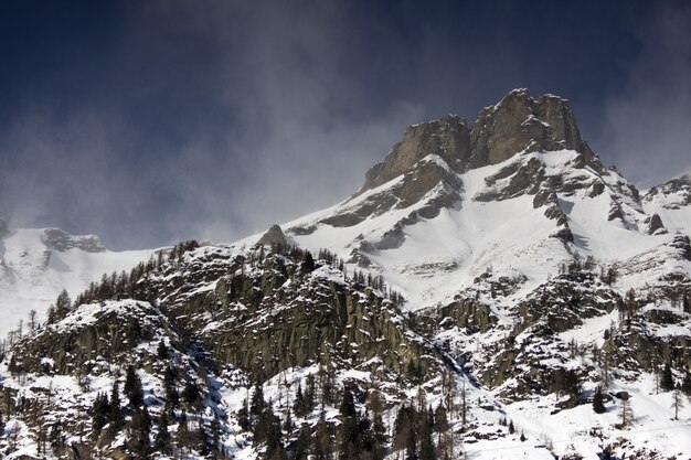 Paysages à couper le souffle des montagnes enneigées sous un ciel nuageux pittoresque