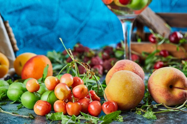 Pêches fraîches, cerises, tranches de citron et menthe sur une surface en marbre