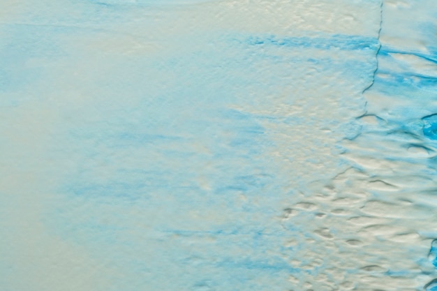 Peinture bleue et blanche sur un mur de béton rugueux