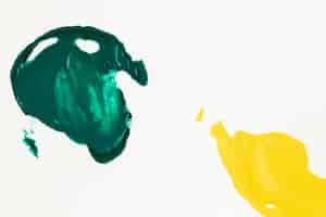 Photo gratuite peinture verte et jaune enduite sur fond blanc