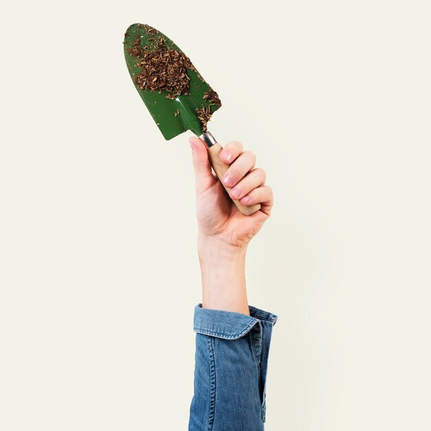 Pelle de jardinage tenue par la main d'une femme