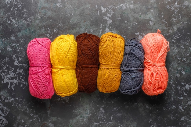 Pelotes de laine de différentes couleurs avec aiguilles à tricoter.