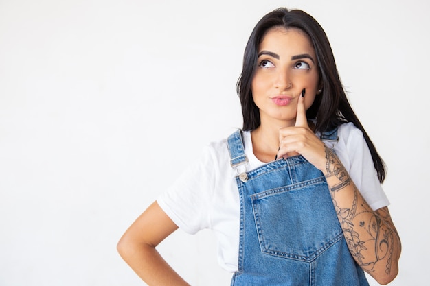 Pensée jeune femme tenant un doigt sur la joue