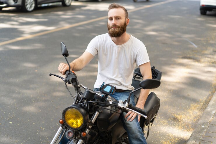 Photo gratuit pensif beau motard posant avec une moto