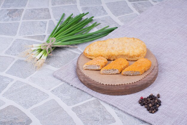 Pépites de poulet et de poisson servies avec bouquet d'oignon.