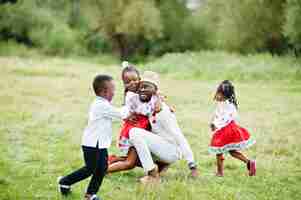 Photo gratuite père africain avec des enfants en vêtements traditionnels au parc