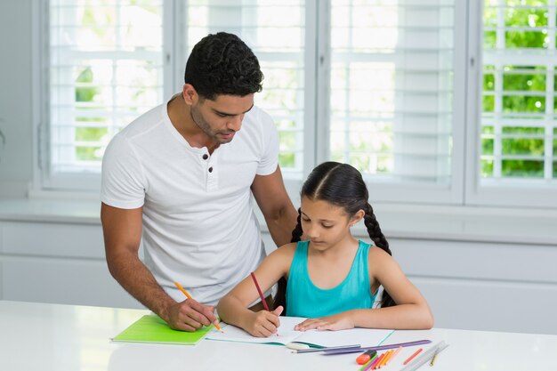 Père aidant sa fille à faire ses devoirs