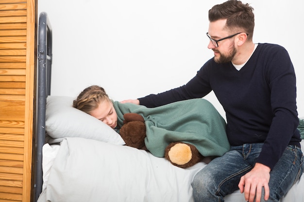 Père amenant sa fille au lit