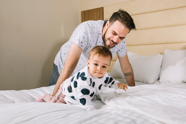 Père avec bébé au lit