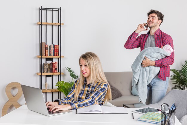 Père avec bébé parle au téléphone