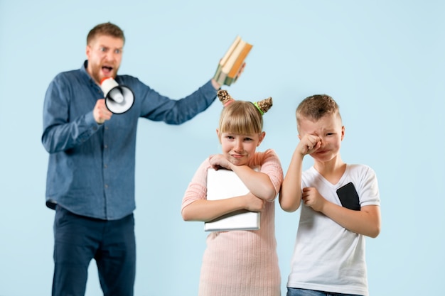 Photo gratuite père en colère grondant son fils et sa fille à la maison.