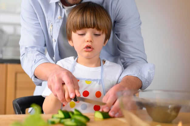 Père et enfant monoparental coupant des légumes