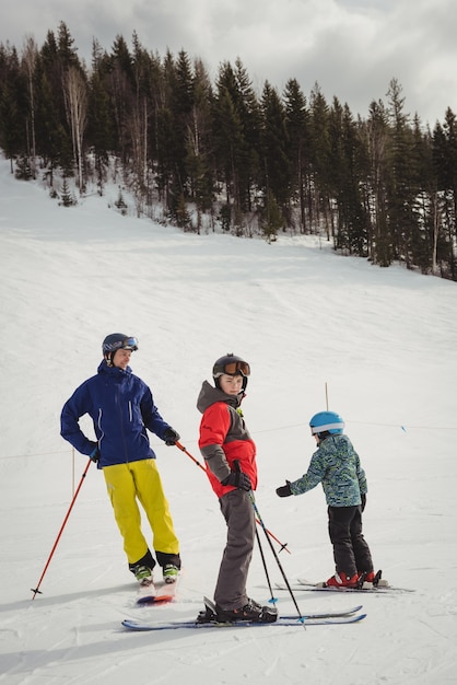Père et enfants skiant sur les Alpes enneigées
