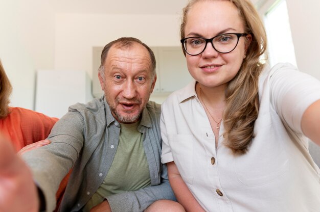 Père essayant de prendre un selfie avec sa fille et sa femme