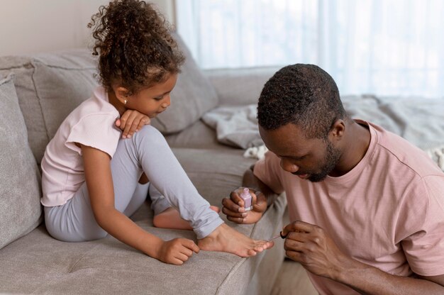 Père faisant les ongles de sa fille