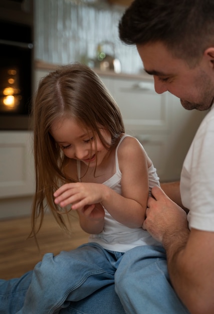 Père faisant rire sa fille en la chatouillant