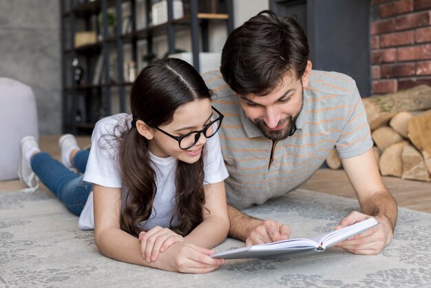 Père et fille à angle élevé lisant