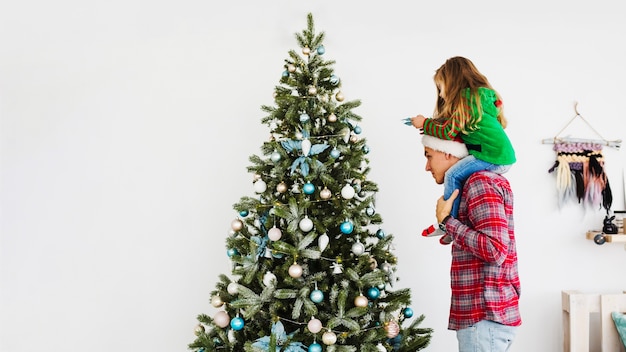 Père et fille, décorer le sapin de Noël