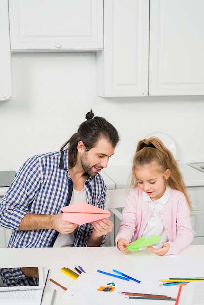 Père et fille jouant avec des avions