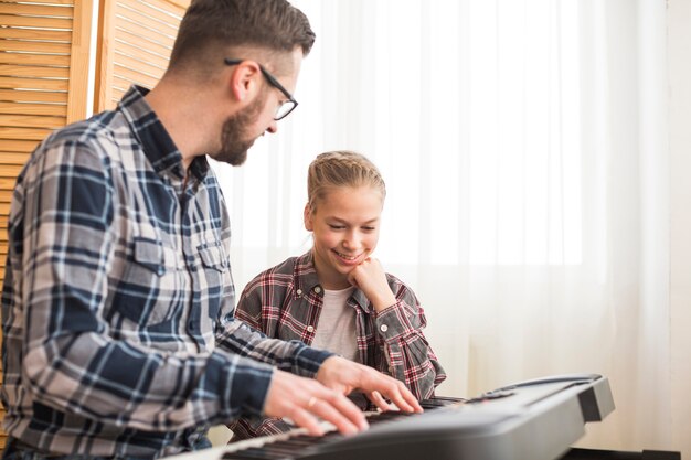 Père et fille jouant du piano