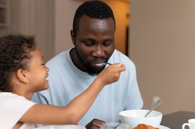 Photo gratuite père et fille mangeant ensemble