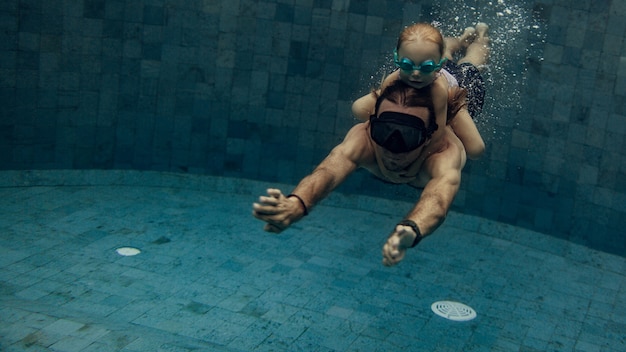 Photo gratuite père et fille nager ensemble dans la piscine