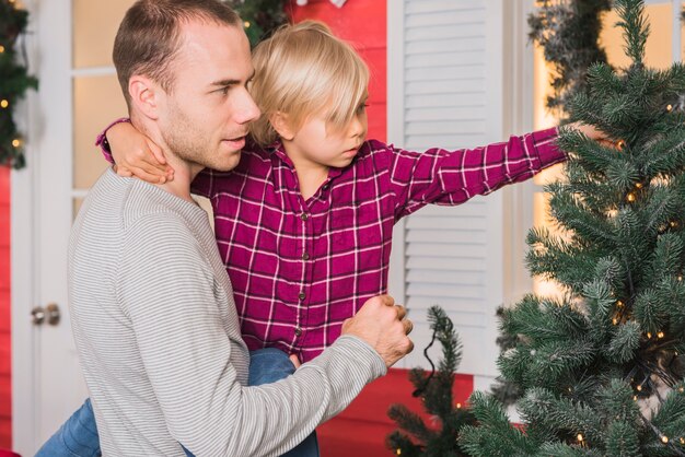 Père et fille regardant l&#39;arbre de Noël