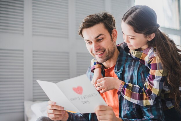 Père et fille en regardant la main carte dessinée le jour des pères