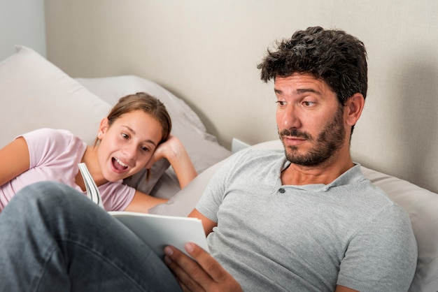 Père et fille regardant une tablette