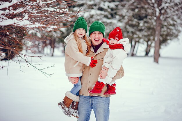 Père avec filles mignonnes dans un parc d&#39;hiver